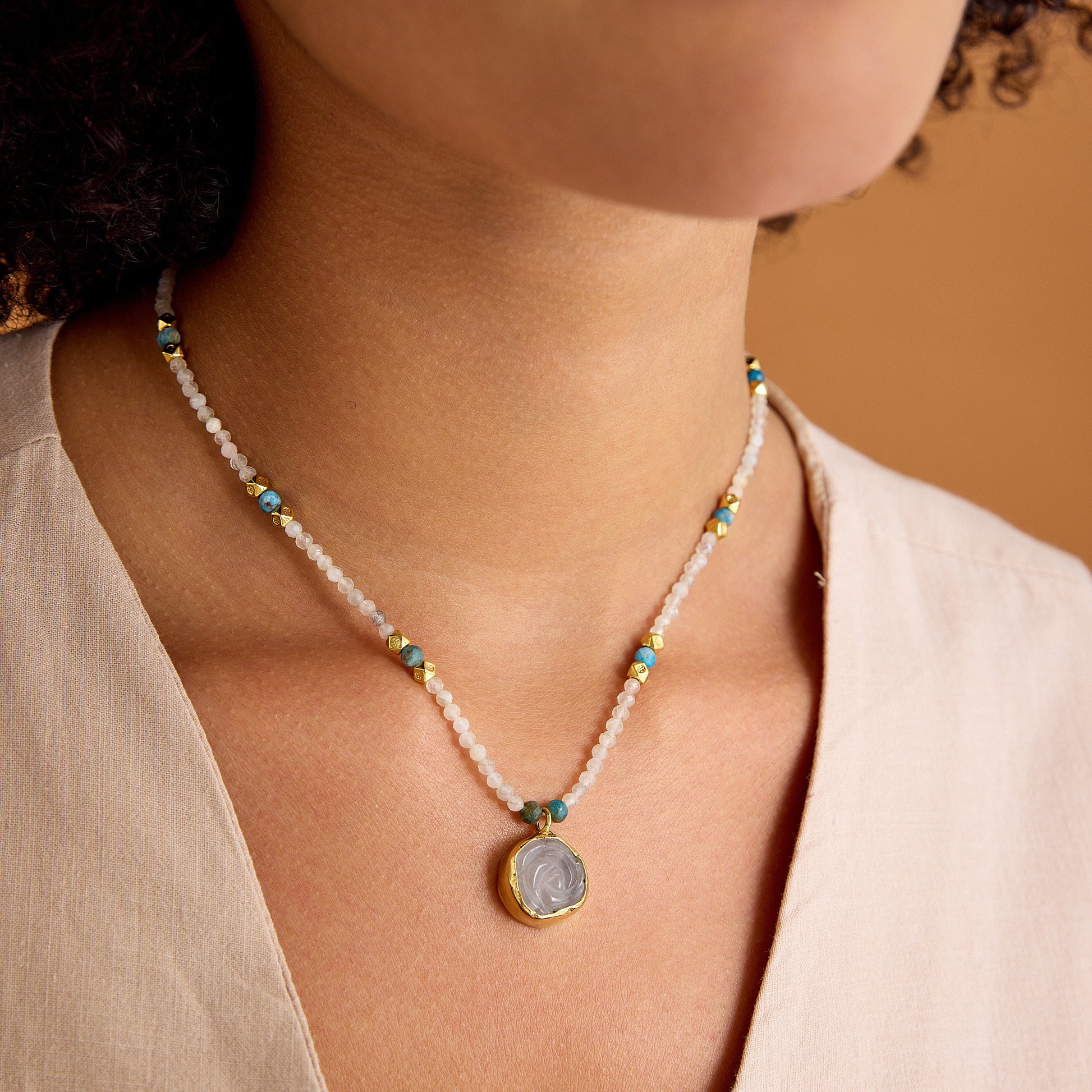 Aytaşı ve apatit boncukları, çiçek formunda pembe kuvars kolye ucu ve 24 ayar altın kaplama detaylarla tasarlanmış minimal, el yapımı kolye.