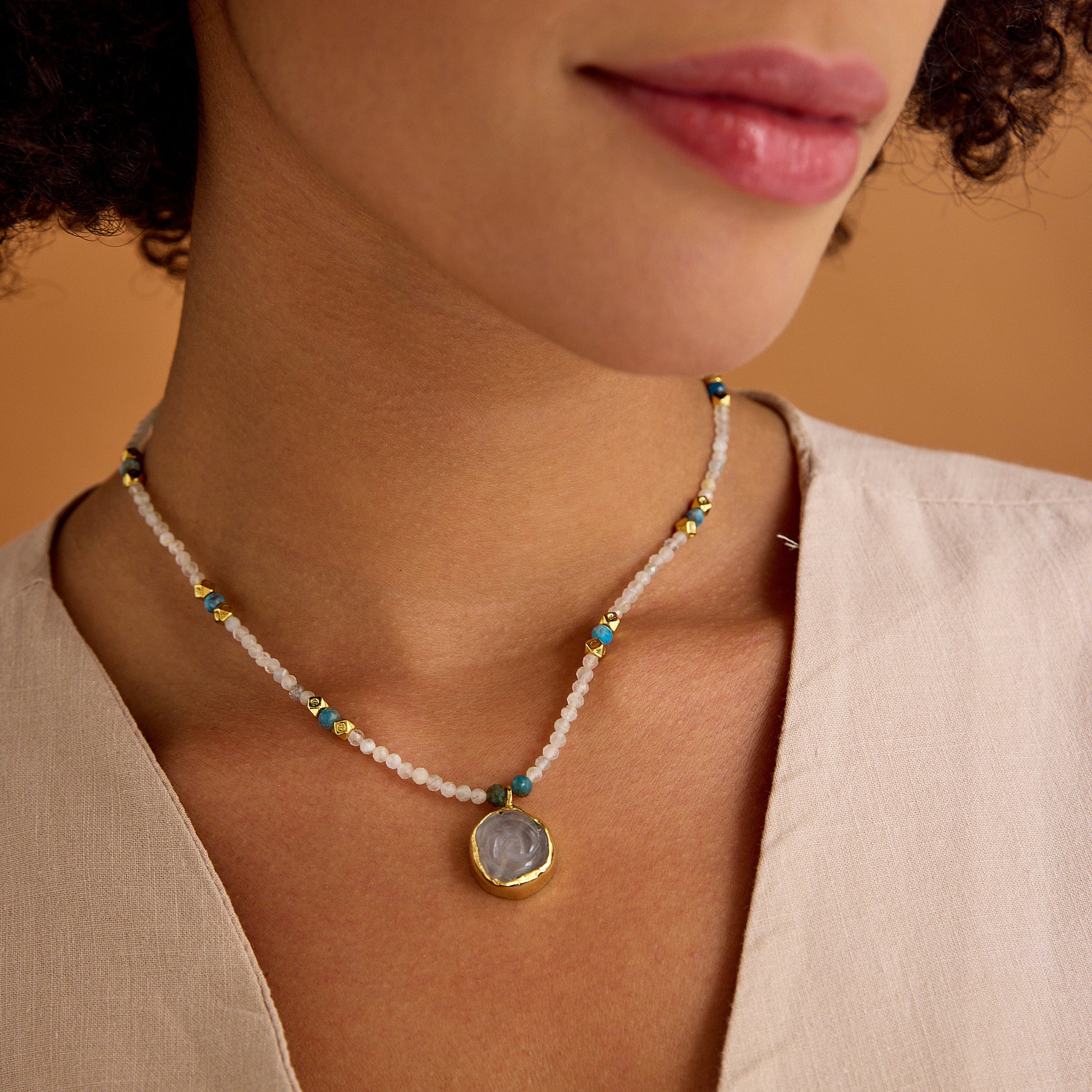 Aytaşı ve apatit boncukları, çiçek formunda pembe kuvars kolye ucu ve 24 ayar altın kaplama detaylarla tasarlanmış minimal, el yapımı kolye.