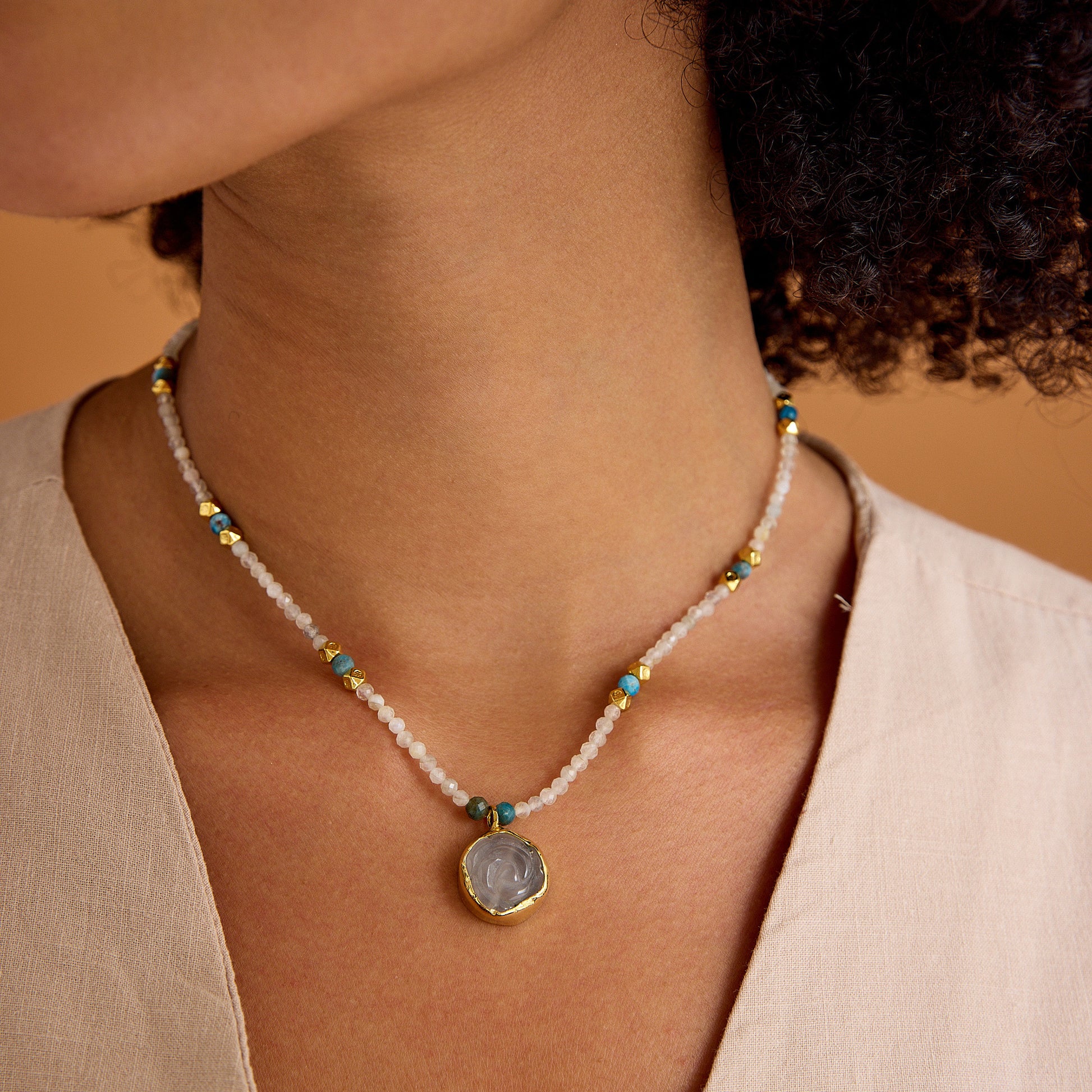 Aytaşı ve apatit boncukları, çiçek formunda pembe kuvars kolye ucu ve 24 ayar altın kaplama detaylarla tasarlanmış minimal, el yapımı kolye.