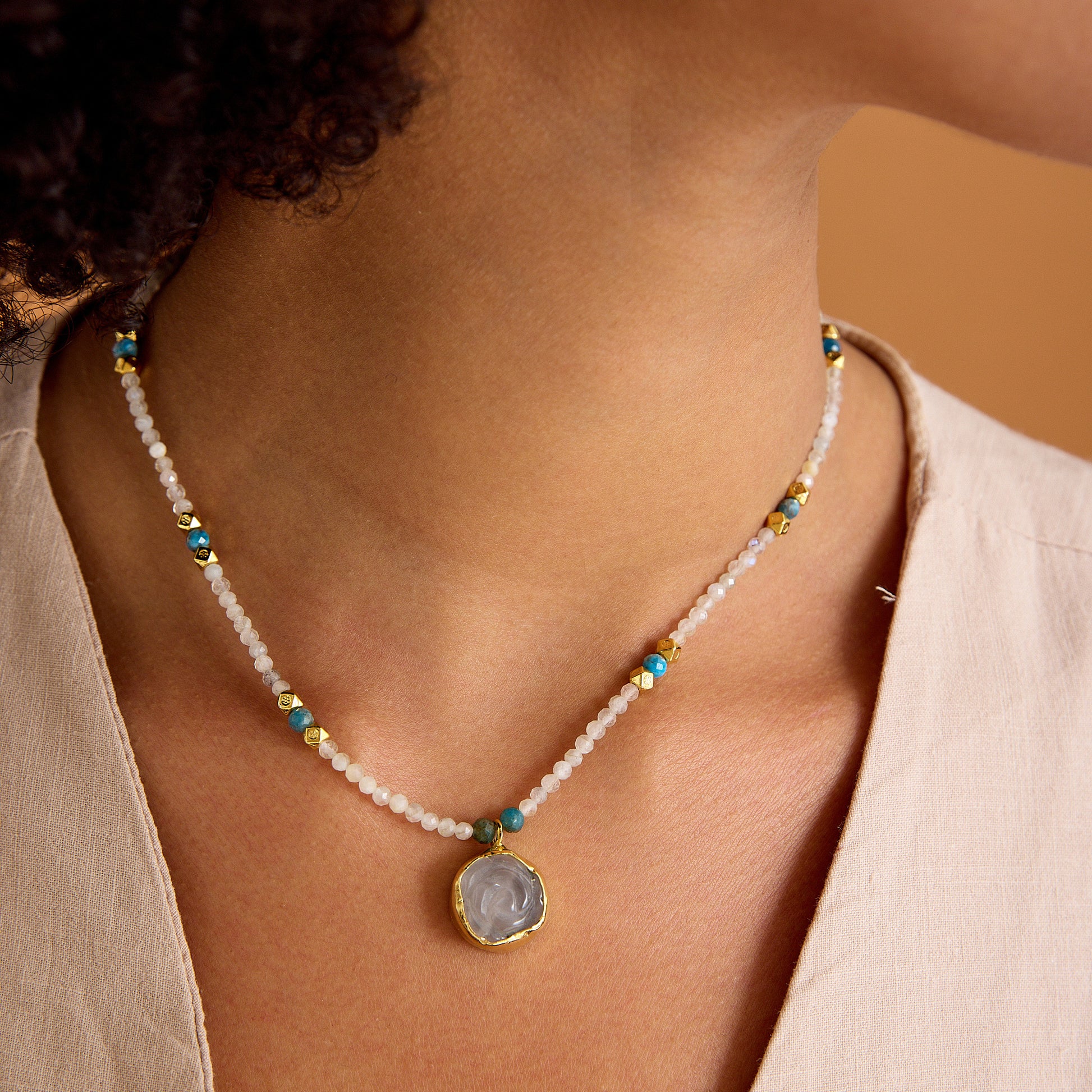 Aytaşı ve apatit boncukları, çiçek formunda pembe kuvars kolye ucu ve 24 ayar altın kaplama detaylarla tasarlanmış minimal, el yapımı kolye.