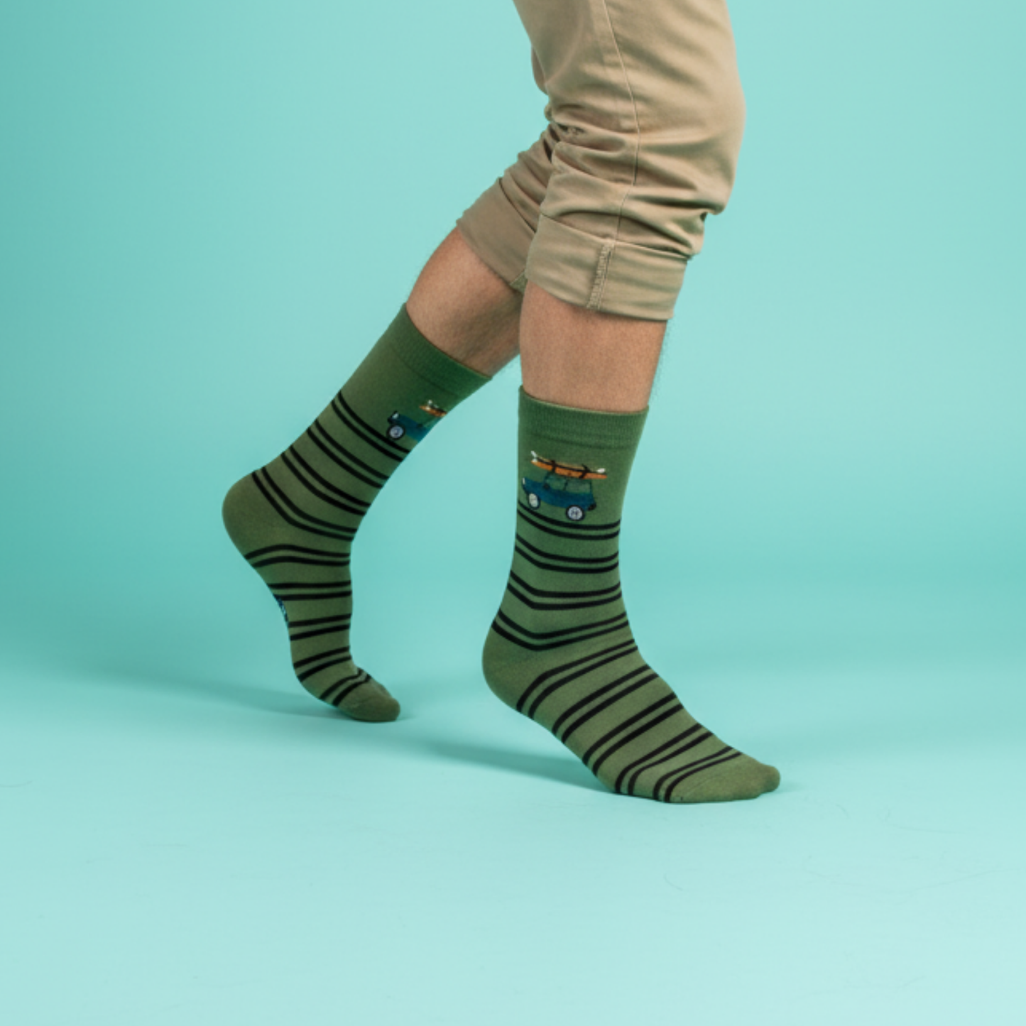Yeşil çizgili zemin üzerinde tavanında sörf tahtası taşıyan jip motifli soket çorap