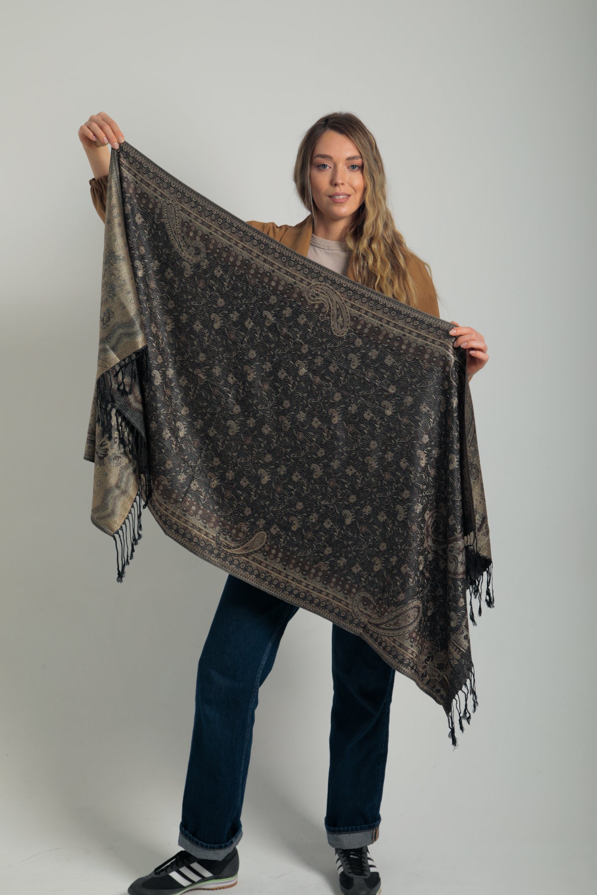 Paisley desenli siyah pashmina şal – kadın tarafından tutulmuş, püsküllü kenarlı, klasik motifli koyu renk şal modeli