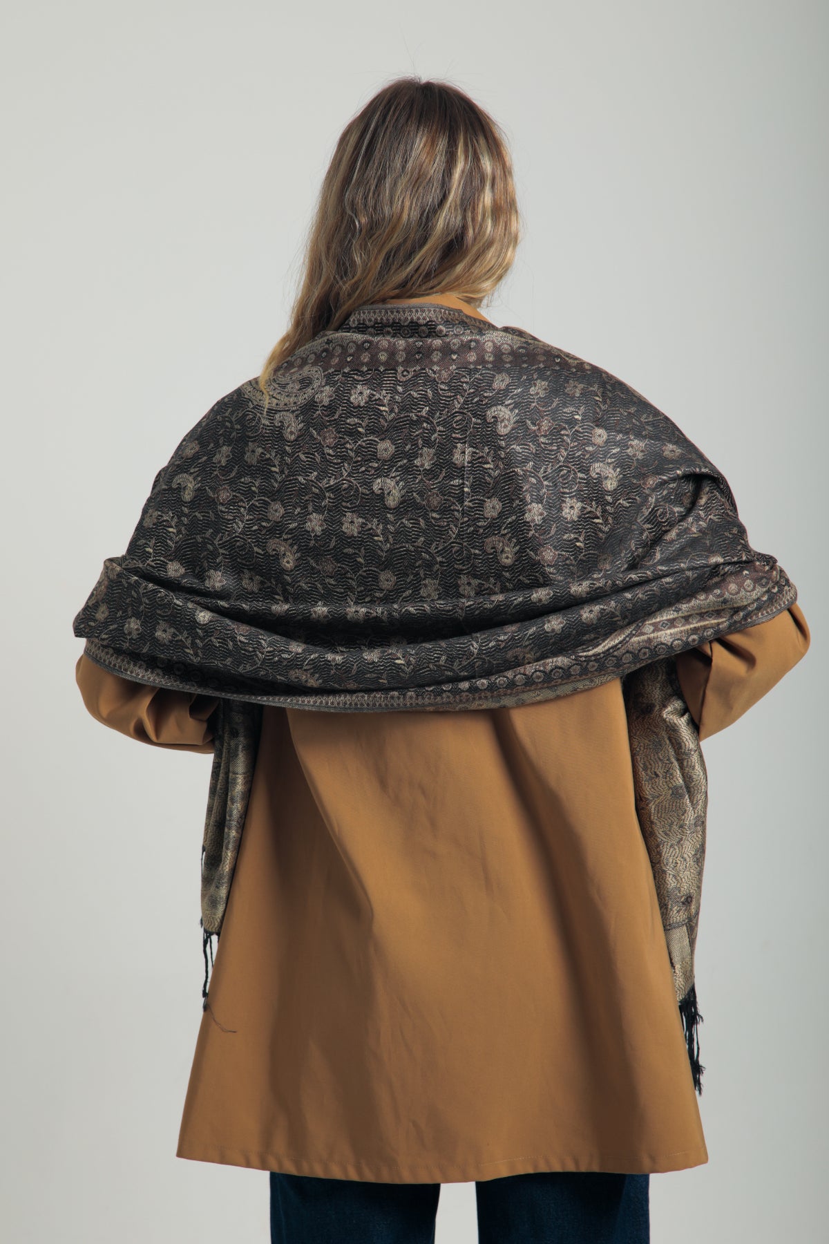 Paisley desenli siyah pashmina şal – kadın tarafından tutulmuş, püsküllü kenarlı, klasik motifli koyu renk şal modeli