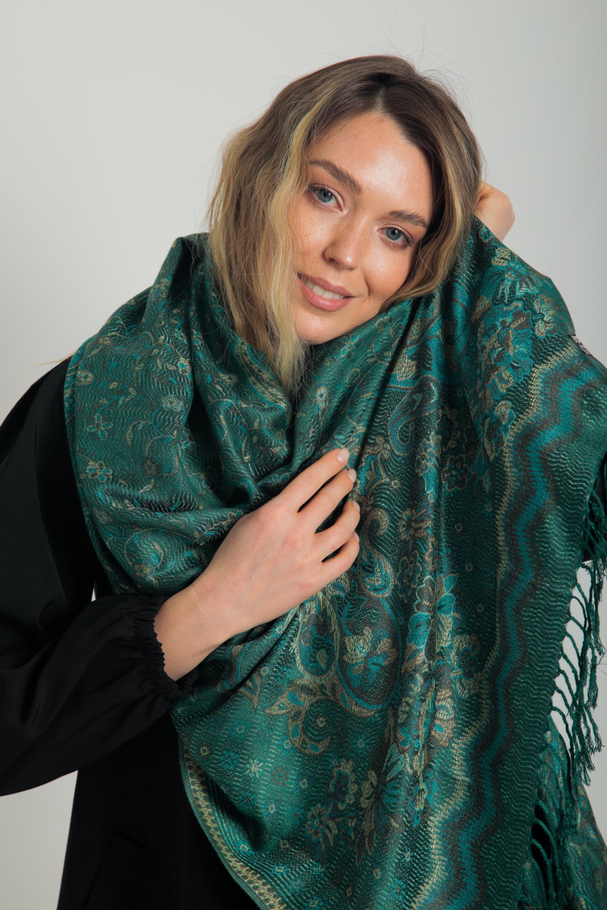 Paisley desenli zümrüt yeşili pashmina şal – püsküllü kenarlı, model tarafından tutulmuş, klasik motifli şık kadın şalı