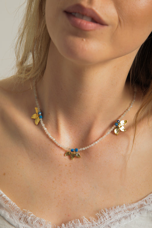 Modelin boynunda görülen, ay taşı boncuklar ve yaprak figürlü altın detaylarla hazırlanmış doğal taş kolye – Pamela.