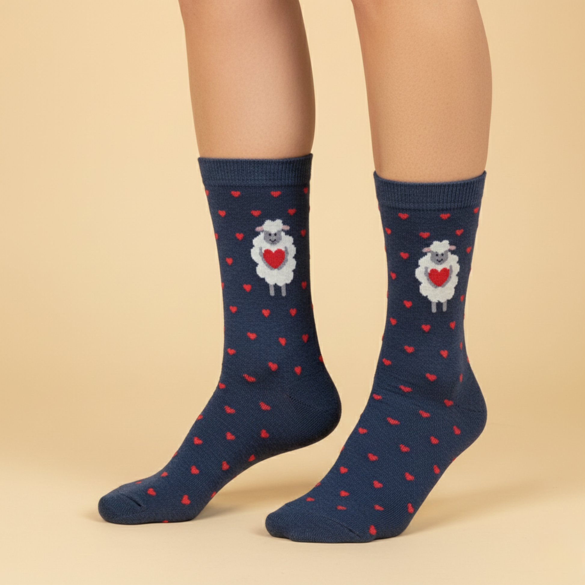 Lacivert zemin üzerine kırmızı kalpli desenler ve kalp tutan koyun figürü bulunan çorap