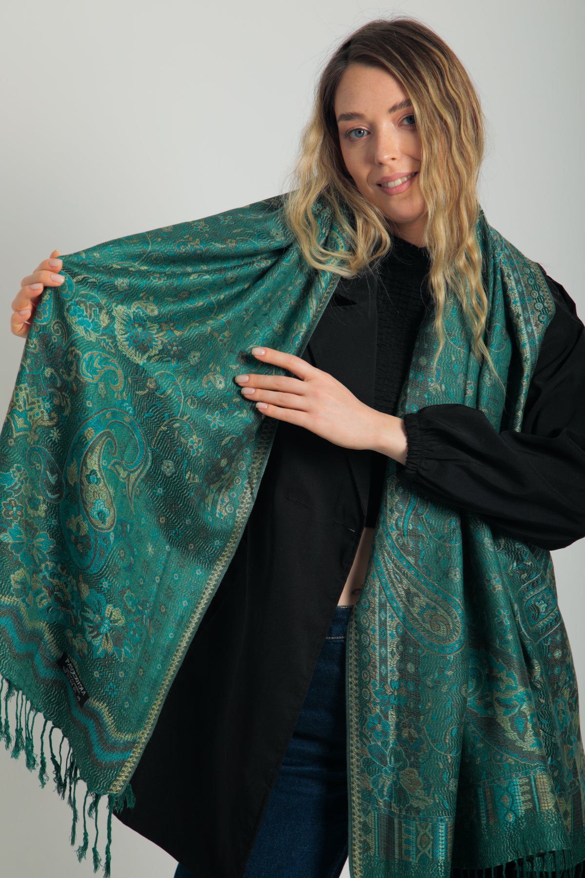 Paisley desenli zümrüt yeşili pashmina şal – püsküllü kenarlı, model tarafından tutulmuş, klasik motifli şık kadın şalı
